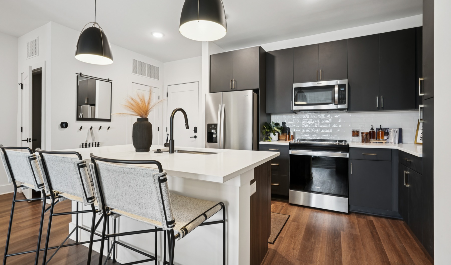 Furnished kitchen with large island and black cabinets